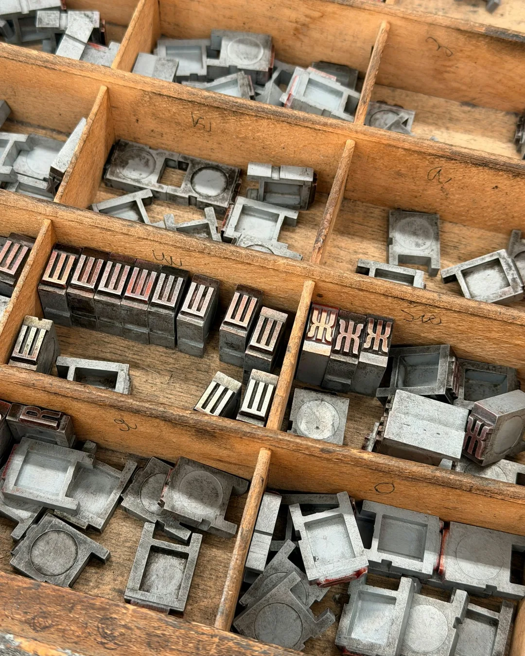 Cajetines de madera con tipos móviles de metal ordenados por letra en un taller de imprenta